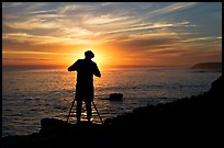 Photographer on cliffs at sunset. Santa Cruz, California, USA