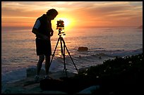 Photographer and large format camera on tripod at sunset. Santa Cruz, California, USA ( color)