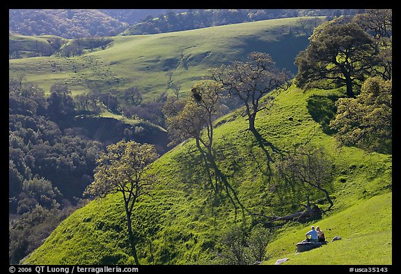Couple sitting on hillside in early spring, Sunol Regional Park. California, USA (color)