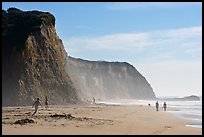 People strolling and playing below cliffs, Scott Creek Beach. California, USA ( color)