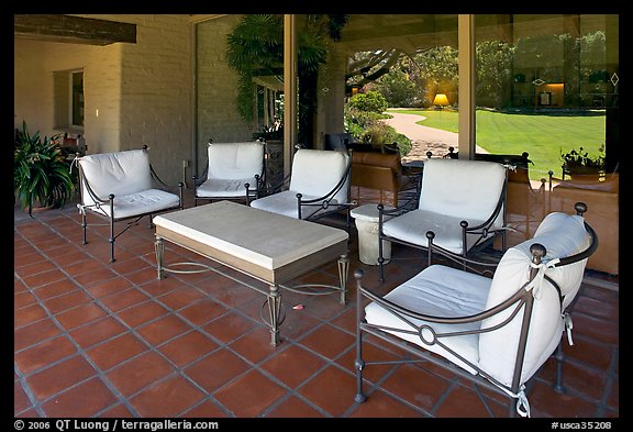 Chairs and coffee table on porch, Sunset gardens reflected. Menlo Park,  California, USA (color)