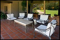 Chairs and coffee table on porch, Sunset gardens reflected. Menlo Park,  California, USA