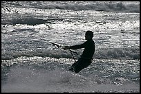 Kitesurfer silhouette against silvery water, Waddell Creek Beach. California, USA