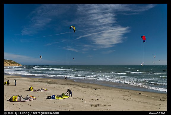 Kitesurfers rolling out sails on on beach, Waddell Creek Beach. California, USA
