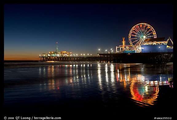 Ferris Wheel and pier reflected on wet sand at night. Santa Monica, Los Angeles, California, USA (color)
