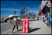 Surfer walking on Ocean Front Walk. Venice, Los Angeles, California, USA (color)