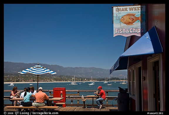 People eating with yachts and beach in background. Santa Barbara, California, USA (color)