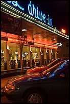 Neon lights of Mels drive-in reflected on parked cars. San Francisco, California, USA