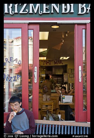 Man biting pizza outside pizzaria, Haight-Ashbury district. San Francisco, California, USA (color)