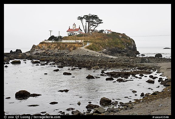 Rocky mound and lighthouse, Crescent City. California, USA (color)