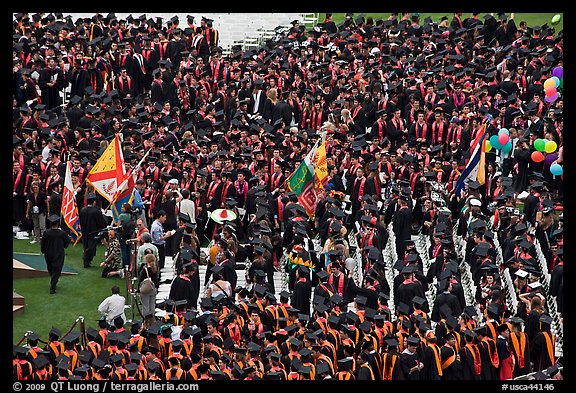 Academic flags exit amongst crow of graduates after commencement ceremony. Stanford University, California, USA (color)