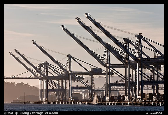 Giant cranes dwarf yacht Port of Oakland. Oakland, California, USA (color)