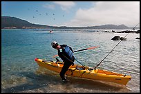 Man boards sea kayak, Carmel Bay. Carmel-by-the-Sea, California, USA