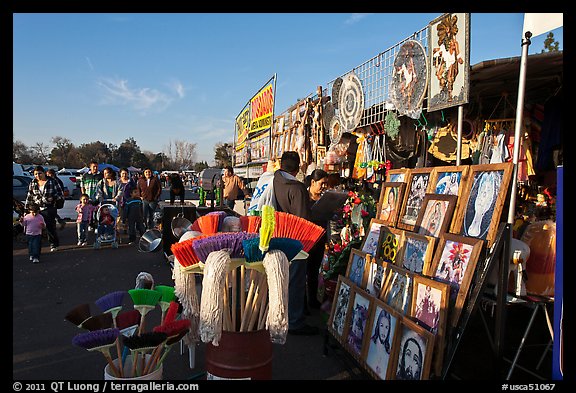 Brooms and religious pictures for sale, San Jose Flee Market. San Jose, California, USA