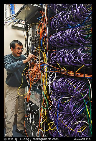 Man with tangle of wires in server room. Menlo Park,  California, USA (color)
