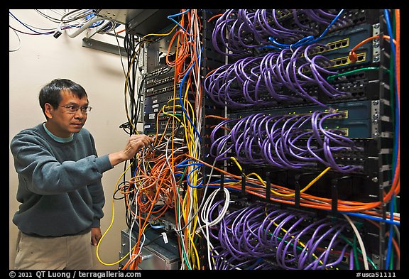 Technician rearranging data cables. Menlo Park,  California, USA (color)