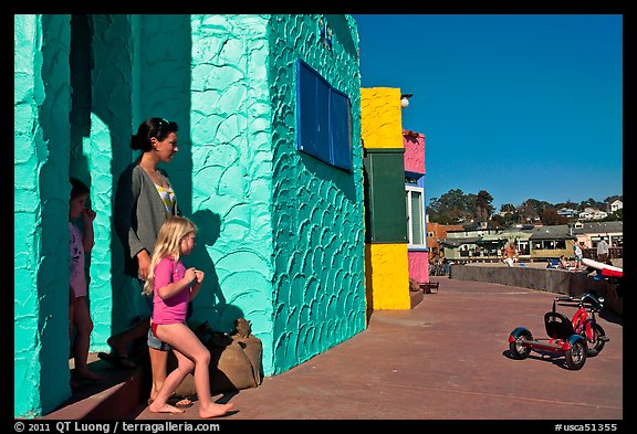 Family steps out of colorful cottage. Capitola, California, USA