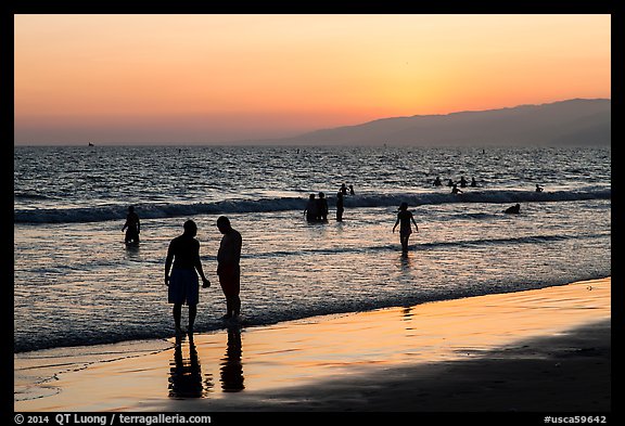 Sunset with beachgoers in water. Santa Monica, Los Angeles, California, USA