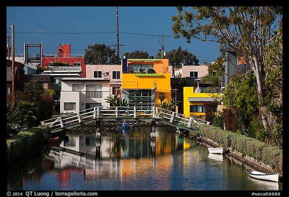 Rower under bridge next to colorful houses. Venice, Los Angeles, California, USA (color)