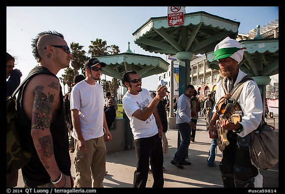 Tourists photograph Ocean Front Walk entertainer. Venice, Los Angeles, California, USA (color)