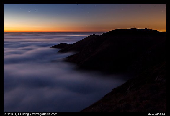 Hills emerging from sea of clouds at dusk, Garrapata State Park. Big Sur, California, USA