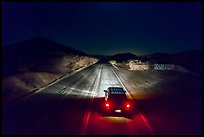 Aerial view of car shining headlights on highway 66 maker at night. Mojave Trails National Monument, California, USA ( color)
