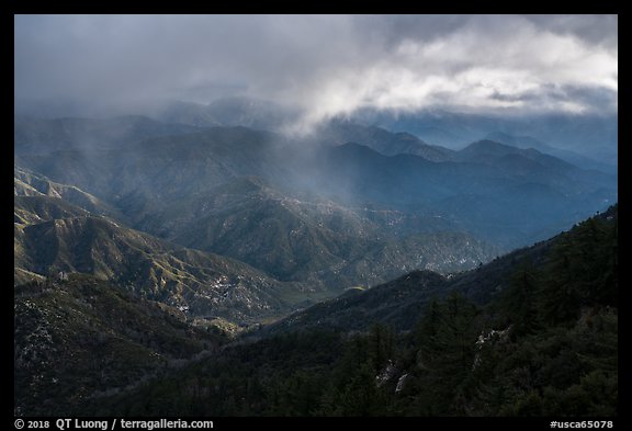 Rolling peaks under storm sky with shaft of light. San Gabriel Mountains National Monument, California, USA