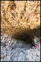 Hiker at entrance of Skull Cave. Lava Beds National Monument, California, USA ( color)