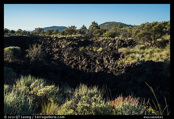 Lava depression and distant buttes. Lava Beds National Monument, California, USA (color)