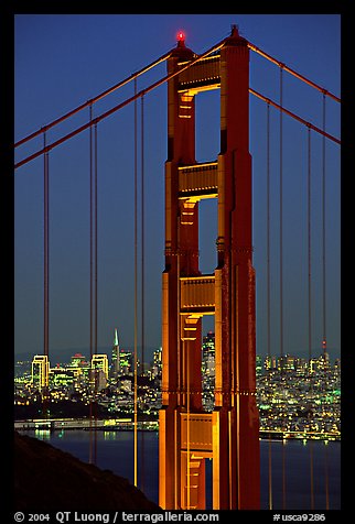 The city seen through the cables and pilars of the Golden Gate bridge, night. San Francisco, California, USA