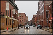 Downtown street lined with brick buildings in the rain, Lowell. Massachussets, USA