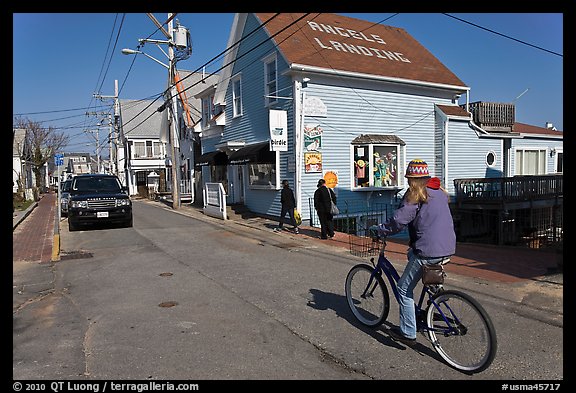 Woman biking on main street, Provincetown. Cape Cod, Massachussets, USA (color)