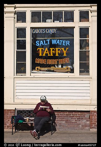 Man reading in front of Salt Water taffy store, Provincetown. Cape Cod, Massachussets, USA