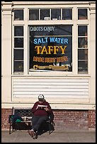Man reading in front of Salt Water taffy store, Provincetown. Cape Cod, Massachussets, USA (color)