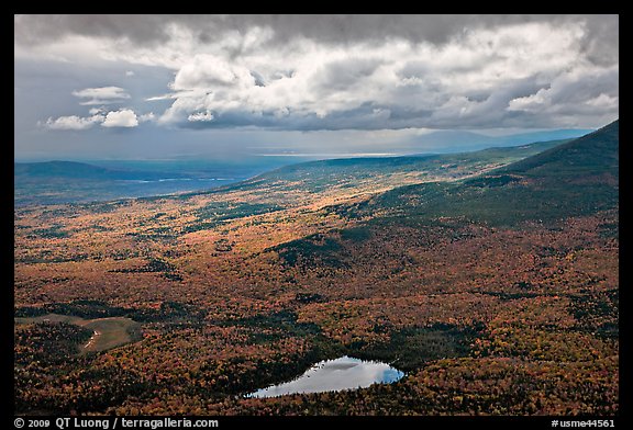 View with storm light and clouds over slopes covered with fall foliage. Baxter State Park, Maine, USA
