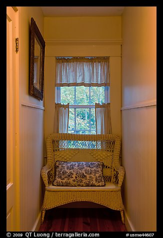 Corridor in inn with chair and window looking out to trees. Maine, USA