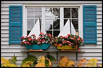 Window with flower pots shaped like sailboats. Bar Harbor, Maine, USA