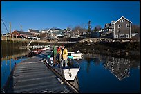 Men preparing to leave on small boat. Stonington, Maine, USA