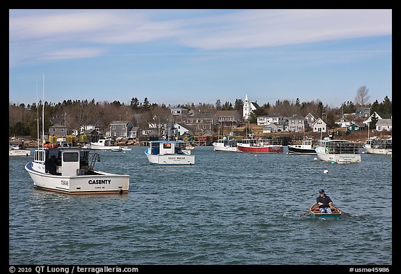 Man paddling to board lobster boat. Corea, Maine, USA