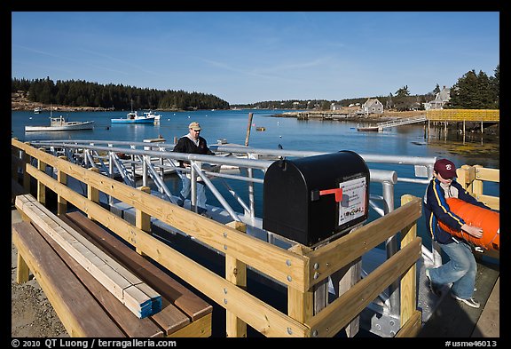 Mailbox and people unloading mailboat. Isle Au Haut, Maine, USA (color)