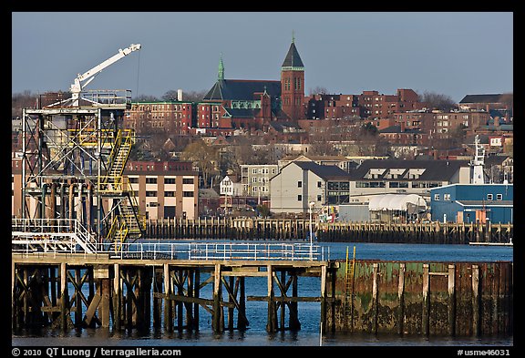 Pier and hillside buildings across harbor. Portland, Maine, USA