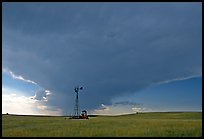 Windmill and tractor under a threatening stormy sky. North Dakota, USA ( color)