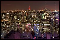 Woman on observation platform of Rockefeller center at night. NYC, New York, USA (color)