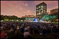Crowd sitting on lawn during evening outdoor concert, Central Park. NYC, New York, USA (color)