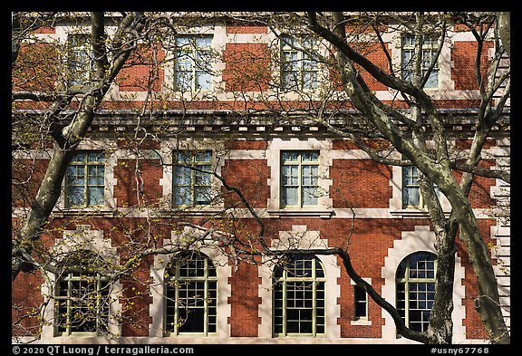 Trees and main building facade, Ellis Island, Statue of Liberty National Monument. NYC, New York, USA