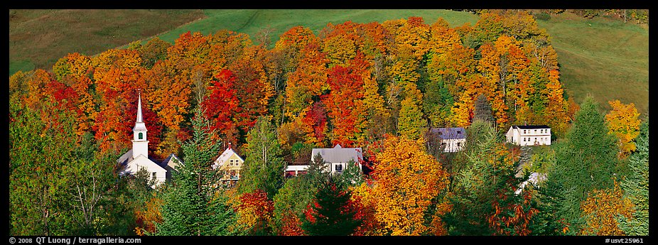 White-steppled church and houses amongst trees in fall foliage. Vermont, New England, USA (color)