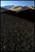 Dark pumice, cinder cones, and Pioneer Mountains. Craters of the Moon National Monument and Preserve, Idaho, USA ( color)