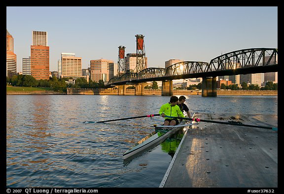 Rowers on double-oar shell lauching from deck in front of skyline. Portland, Oregon, USA