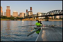 Rowers on double-oar shell lauching from deck in front of skyline. Portland, Oregon, USA