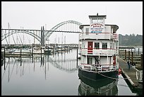 Couple walking on deck next to floating Bed and Breakfast. Newport, Oregon, USA (color)